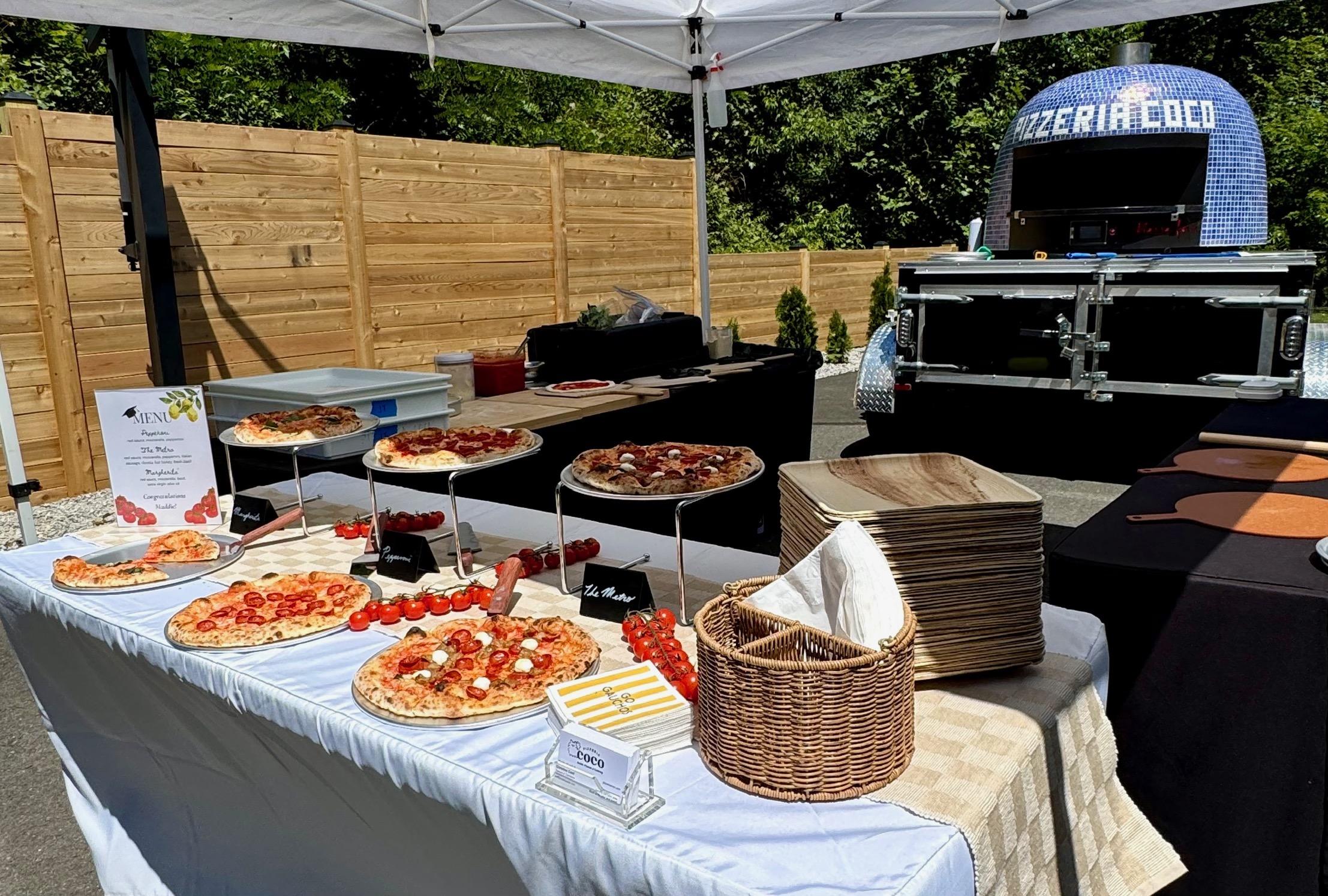 Pizzeria Coco catering spread of wood-fired pizzas laid out for a group
